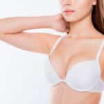 Cropped half-turned closeup photo woman's breast dressed in white bra