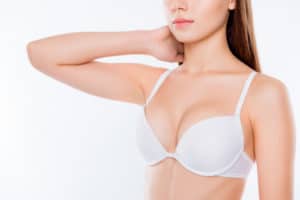 Cropped half-turned closeup photo woman's breast dressed in white bra