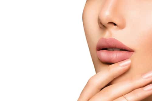 Beauty Fashion woman lips with natural Makeup and beige Nail polish.