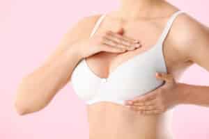 Young,Woman,Checking,Her,Breast,On,Color,Background.,Cancer,Awareness