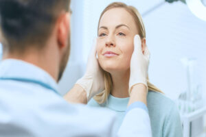 Doctor examining a woman's face to see if she is ready for a facelift in San Antonio, TX