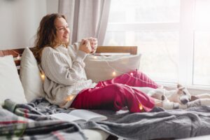 Woman cozy in bed recovering from liposuction in the winter in San Antonio, TX